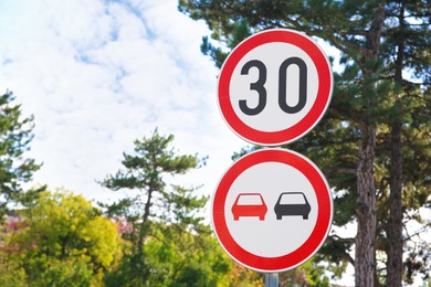 Photo of Post with road signs Maximum Speed 30 and No Overtaking outdoors. Space for text