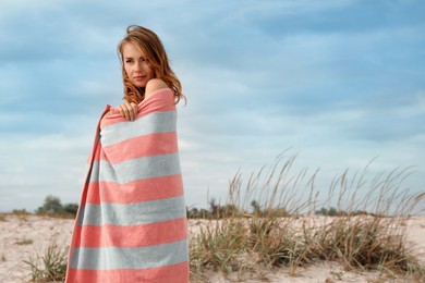 Beautiful woman with beach towel on sand