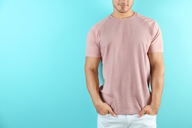 Young man in t-shirt on color background. Mockup for design