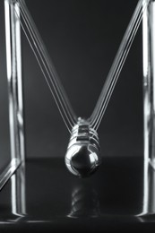 Newton's cradle on dark background, closeup. Physics law of energy conservation