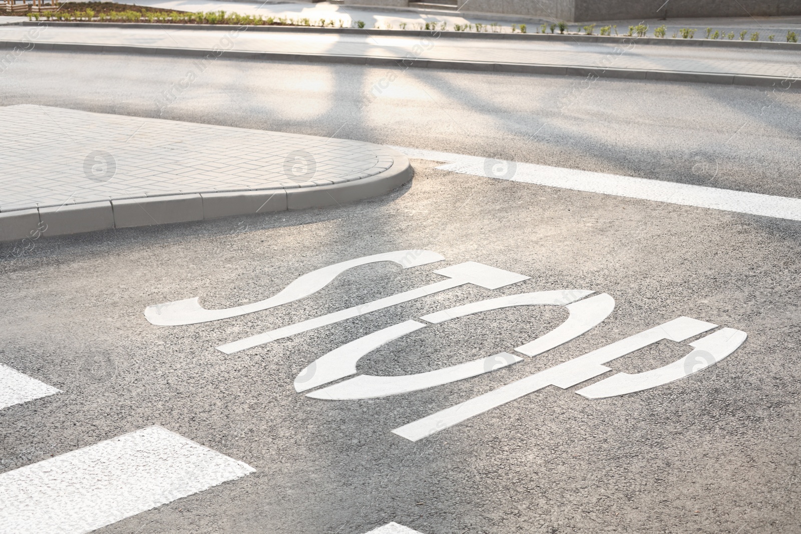 Photo of White sign STOP written on asphalt road outdoors