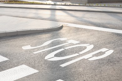 Photo of White sign STOP written on asphalt road outdoors