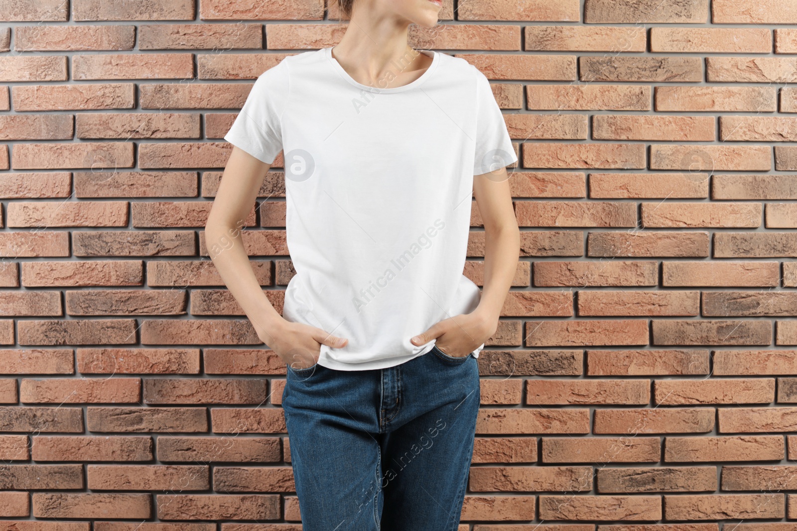 Photo of Woman in white t-shirt near brick wall. Mock up for design