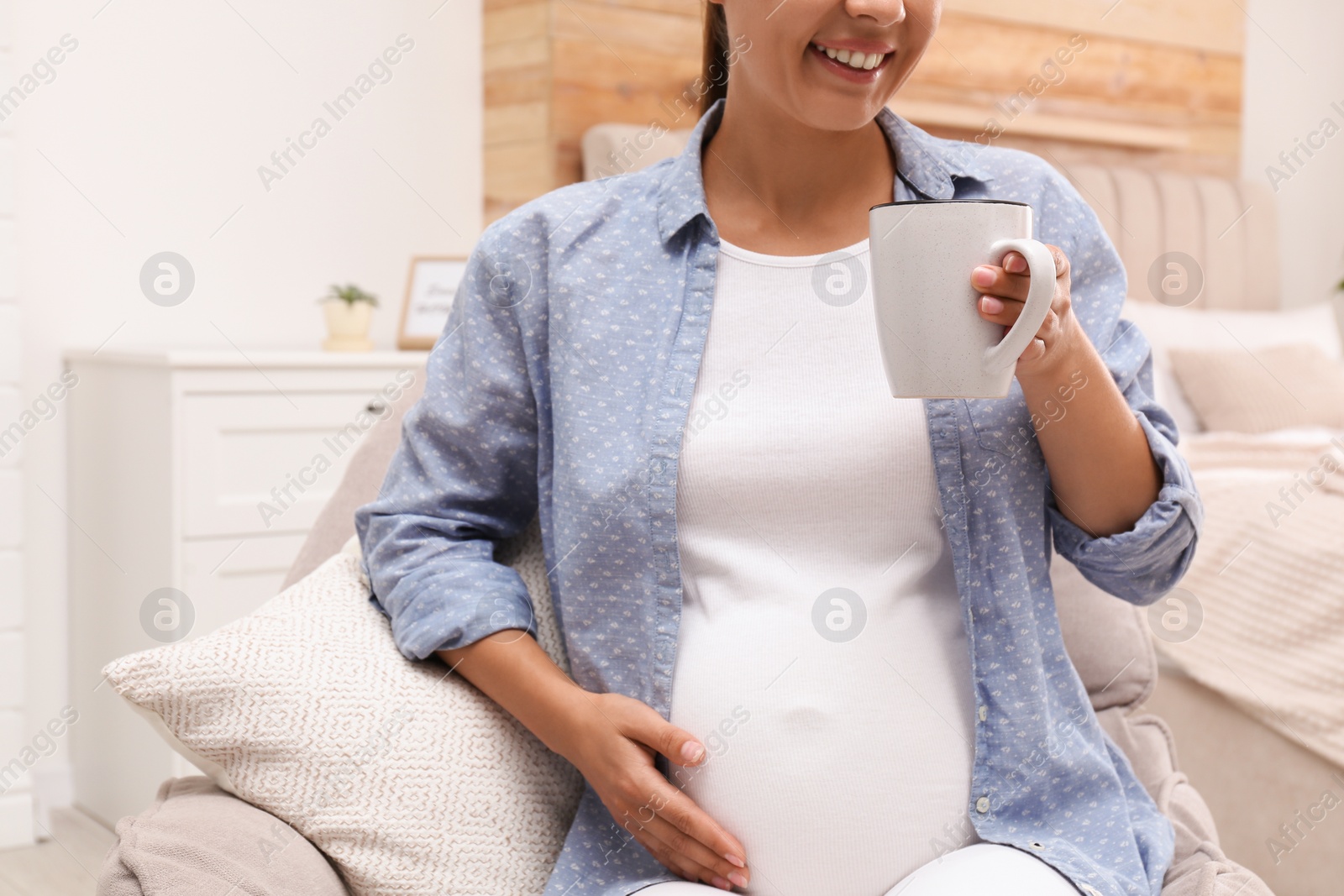 Photo of Pregnant woman drinking tea at home, closeup