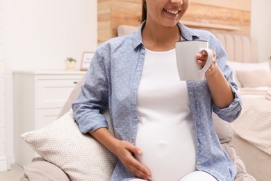 Photo of Pregnant woman drinking tea at home, closeup