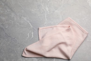 Pink kitchen towel on grey table, top view. Space for text