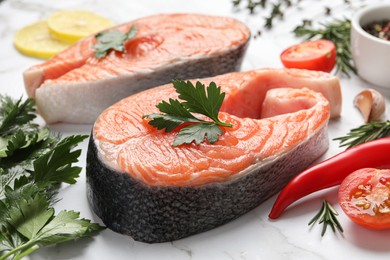 Photo of Fresh salmon and ingredients for marinade on white marble table, closeup
