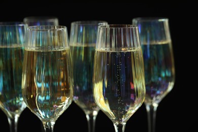 Glasses of champagne on black background, closeup