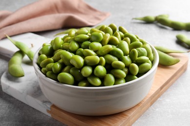 Bowl of delicious edamame beans on table, closeup
