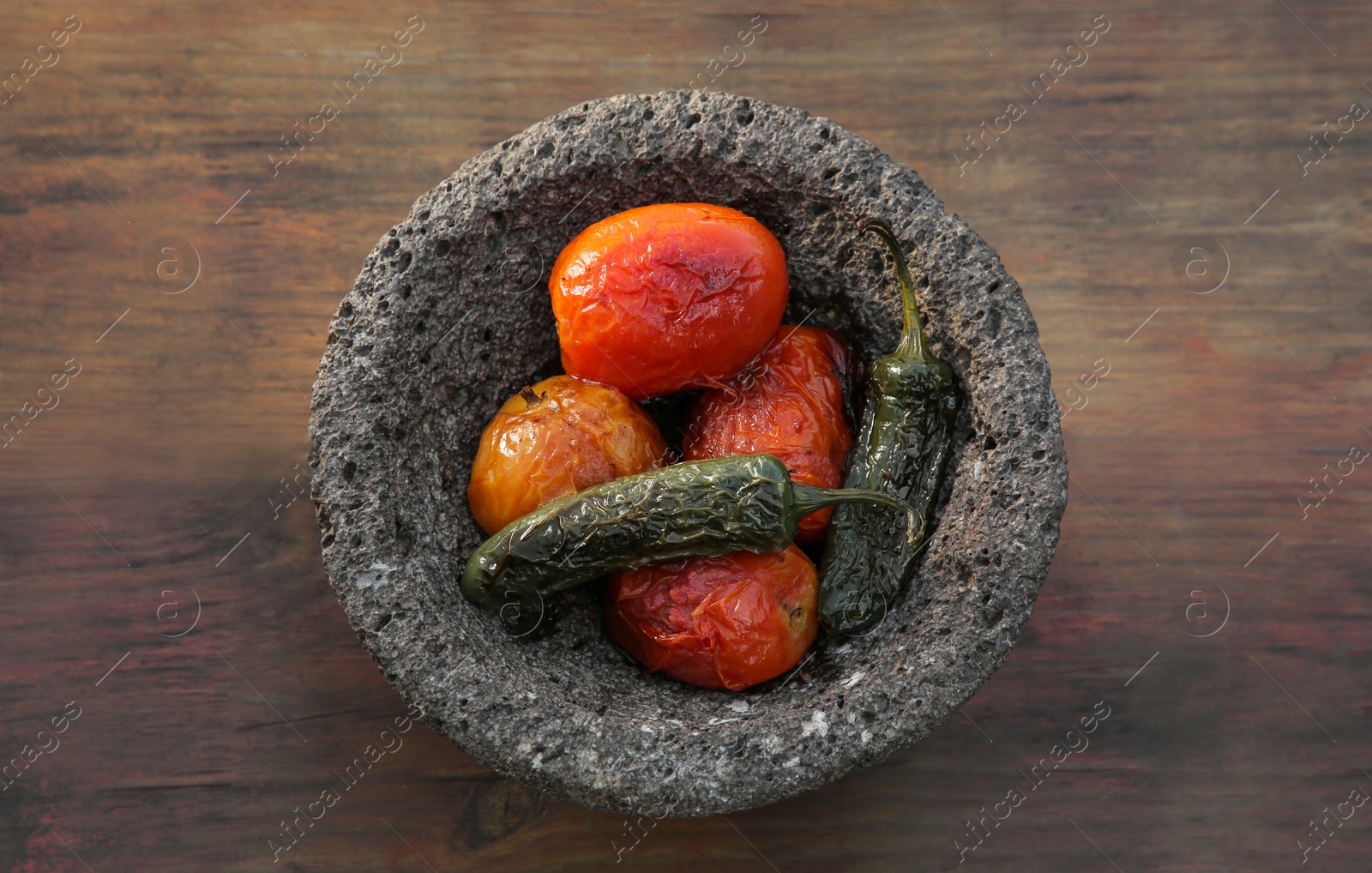 Photo of Ingredients for salsa sauce in stone bowl on wooden table, top view