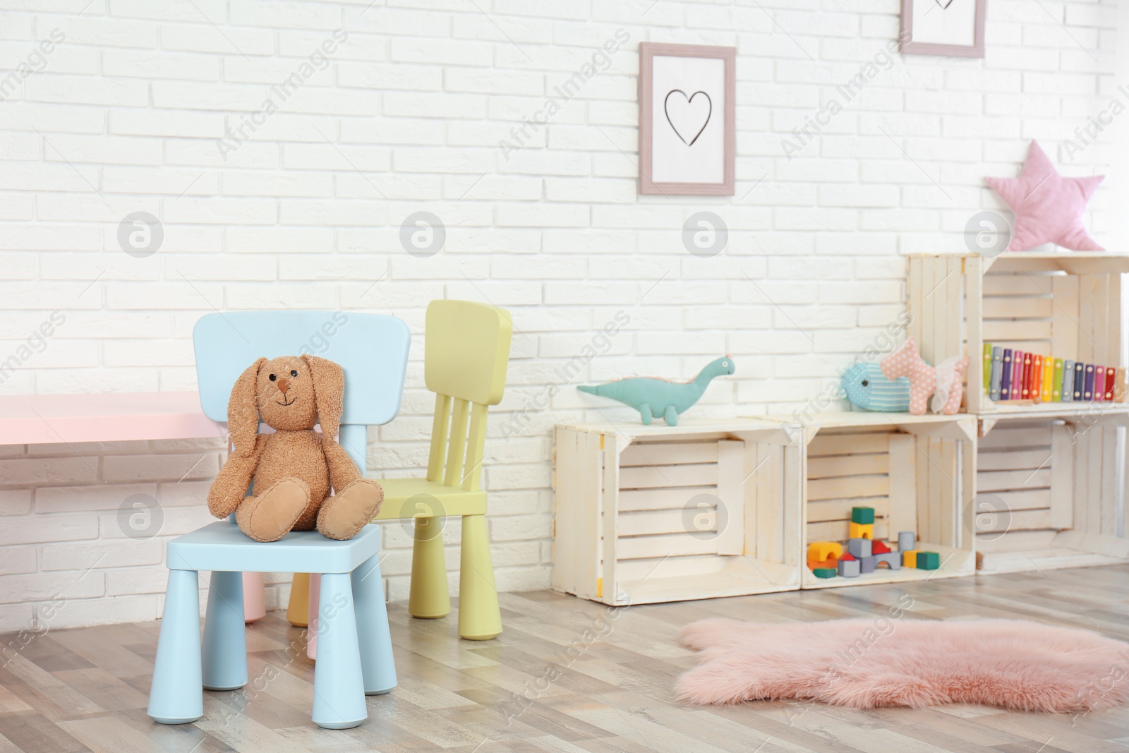 Photo of Cozy kids room interior with table, chairs and toys