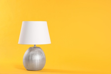 Stylish new night lamp on yellow background. Space for text