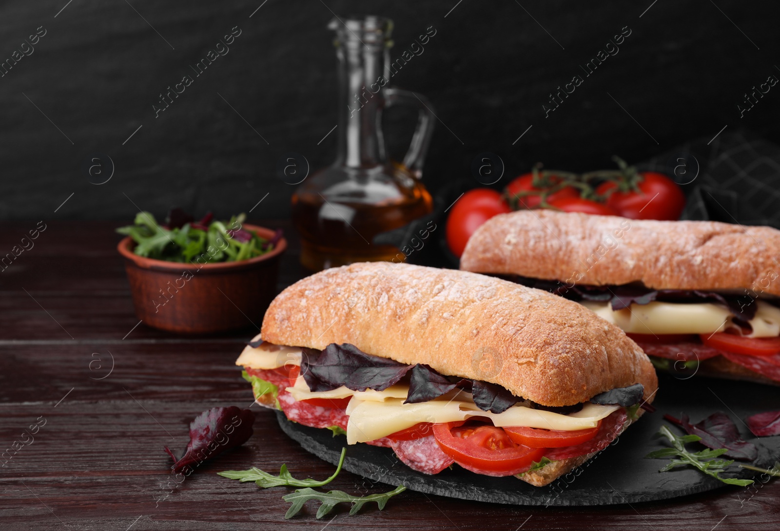 Photo of Delicious sandwiches with cheese, salami, tomato on wooden table