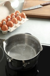 Photo of Pot with boiling water on electric stove in kitchen, space for text