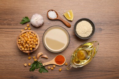 Photo of Different ingredients on wooden table, flat lay. Cooking delicious hummus