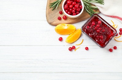 Photo of Flat lay composition with cranberry sauce and orange on white wooden table, space for text