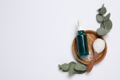 Aromatherapy products. Bottle of essential oil, sea salt and eucalyptus leaves on white background, flat lay. Space for text