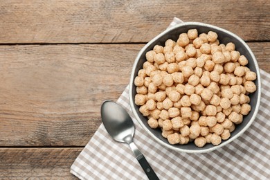 Bowl of sweet crispy corn balls on wooden table, flat lay with space for text. Breakfast cereal