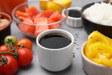 Photo of Ingredients for poke bowl on grey table, closeup