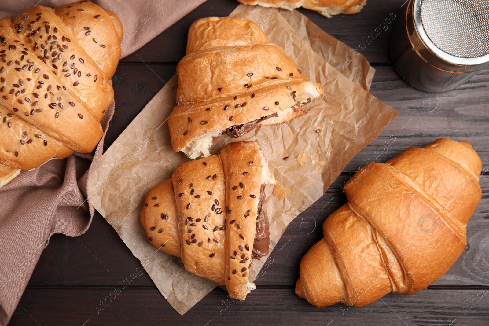 Photo of Fresh croissants with chocolate on wooden table, flat lay