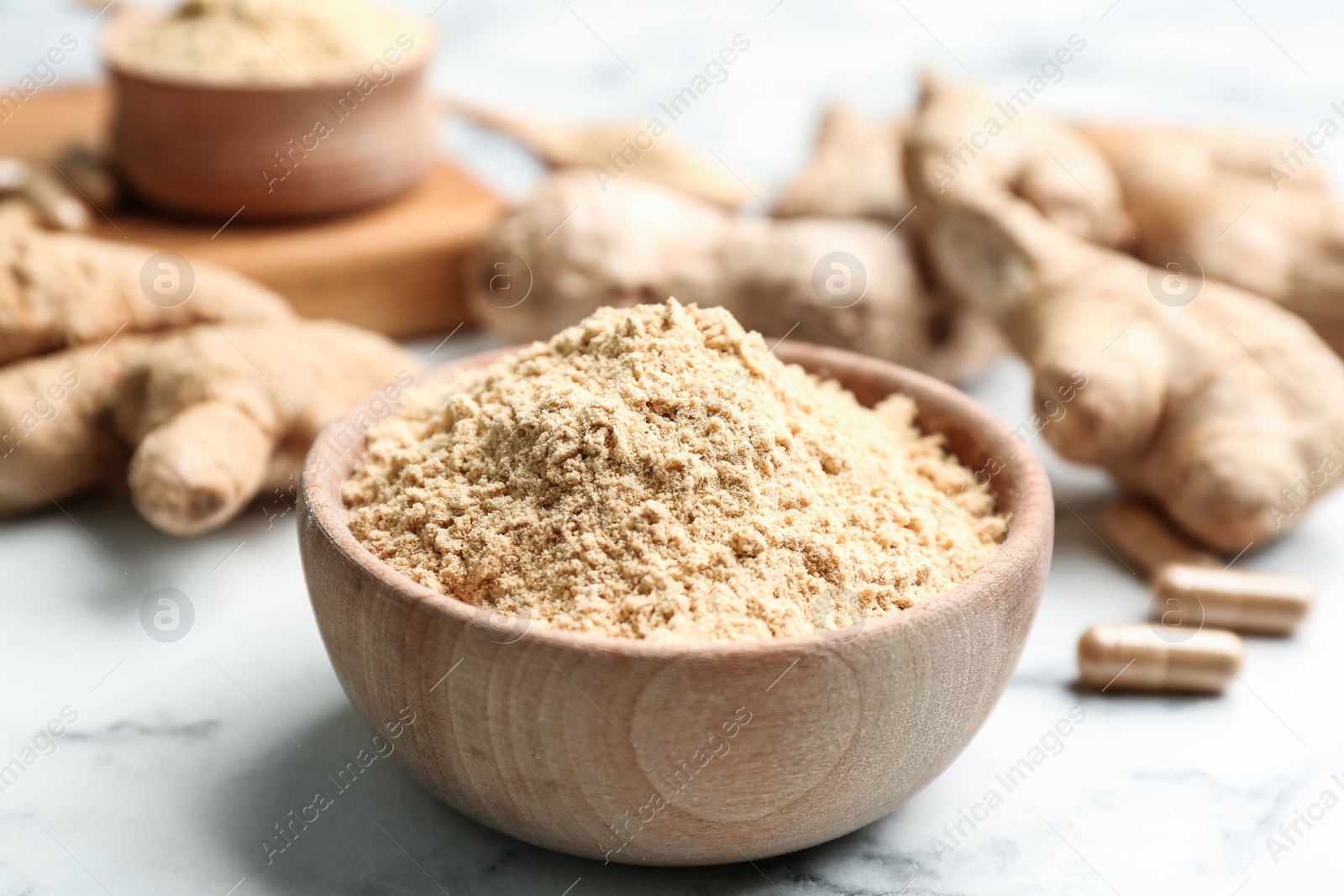 Photo of Dry ginger powder in bowl on white marble table