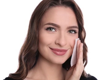 Beautiful woman using mattifying wipe on white background