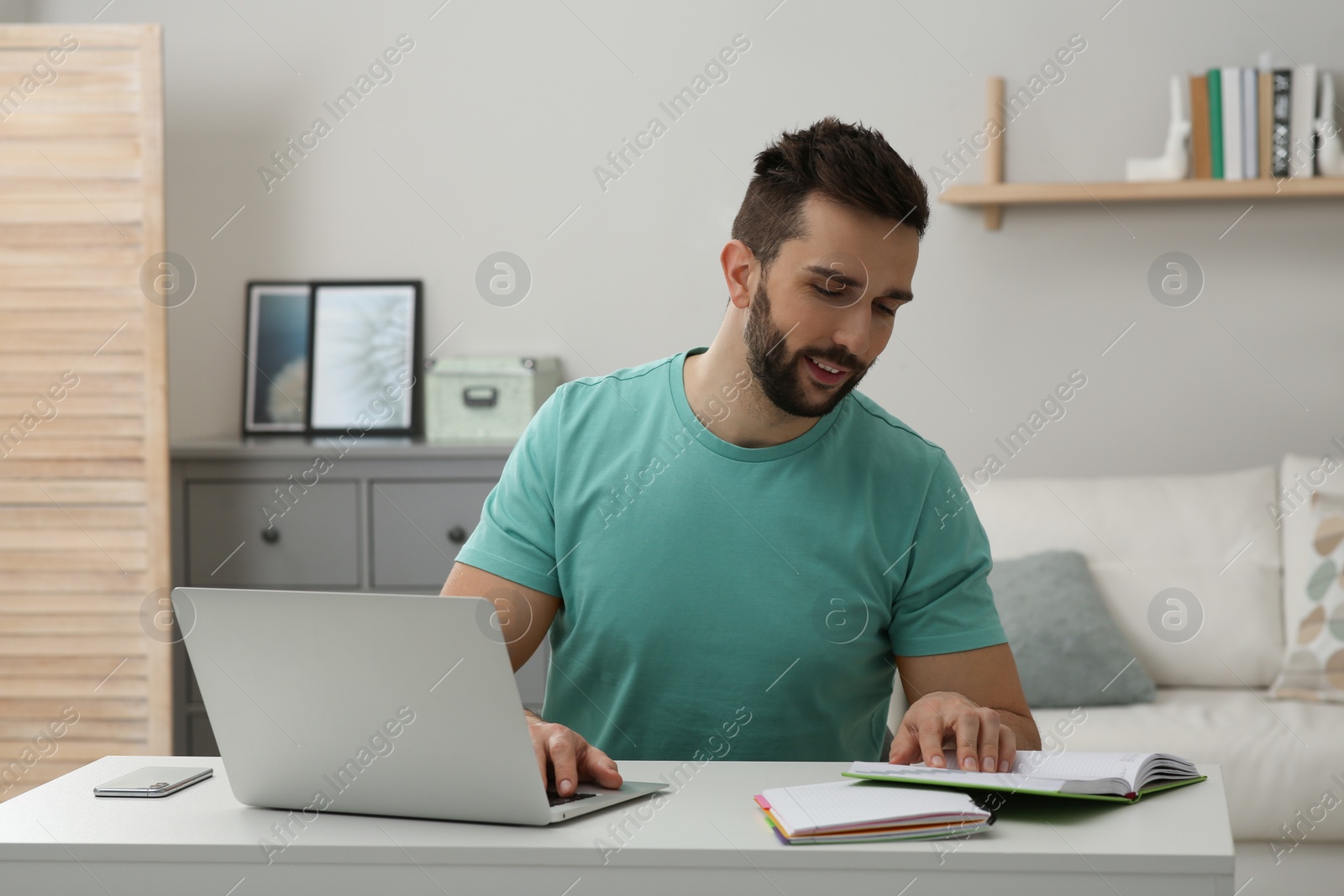 Photo of Online test. Man studying with laptop at home