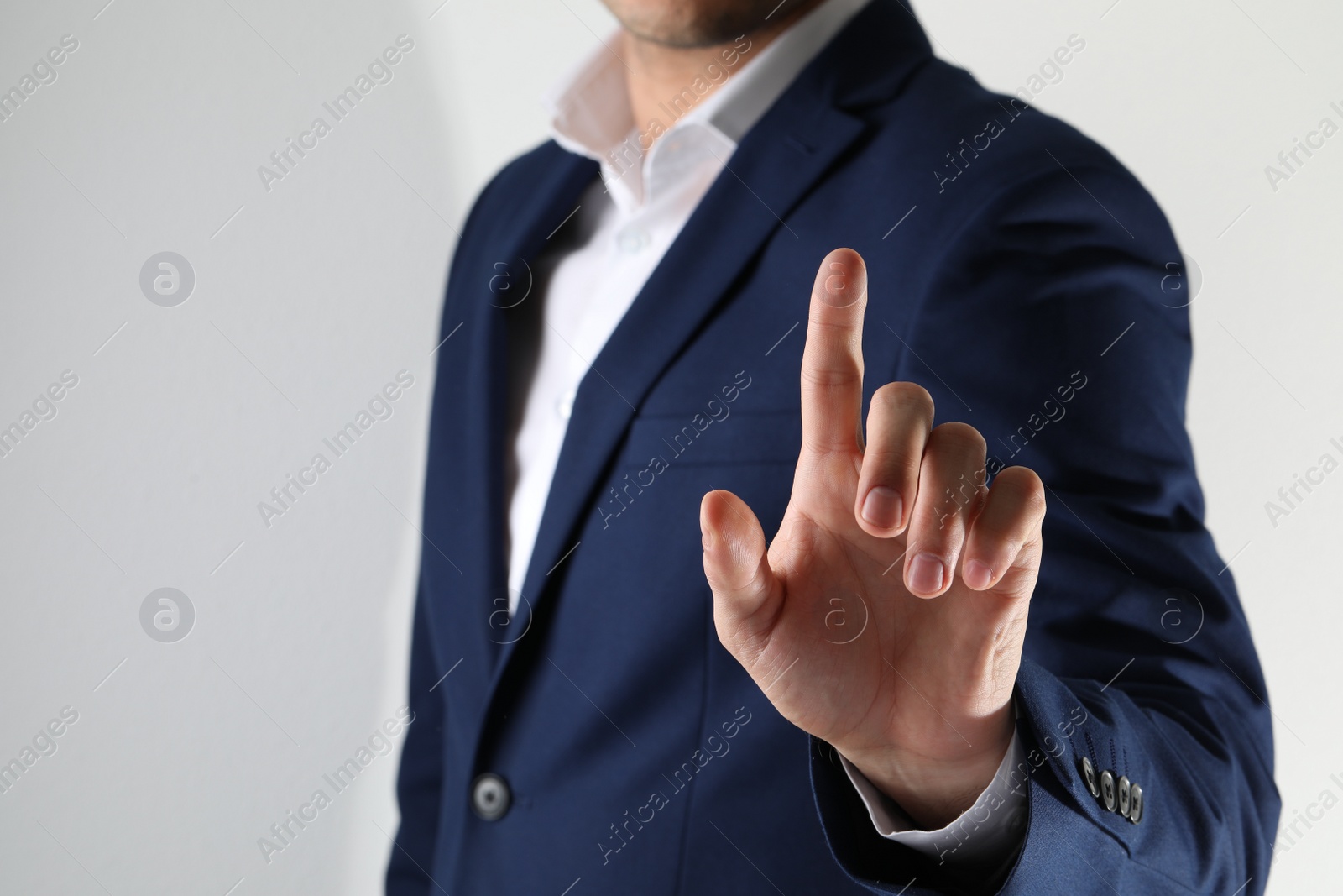 Photo of Man scanning fingerprint on light grey background, closeup