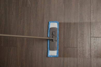 Cleaning of wooden floor with mop, top view