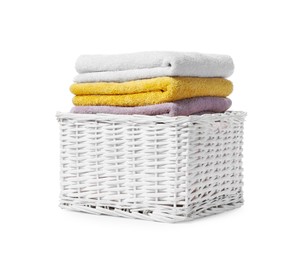 Photo of Wicker laundry basket with folded towels isolated on white