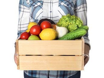 Photo of Woman holding wooden crate filled with fresh vegetables and fruits against white background, closeup
