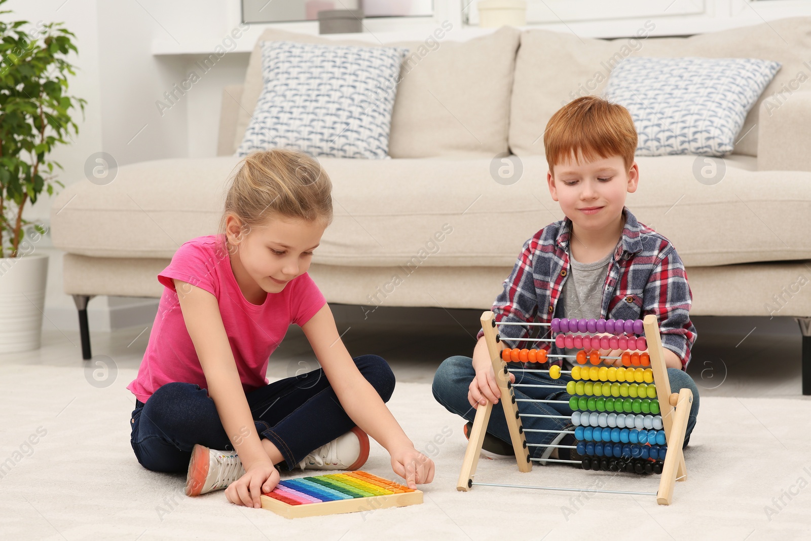 Photo of Children playing with different math game kits on floor in living room. Study mathematics with pleasure