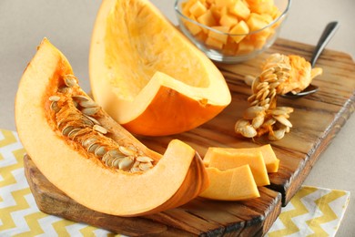 Photo of Cut fresh ripe pumpkin on grey background, closeup