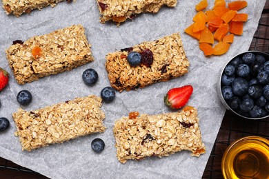 Photo of Tasty granola bars and ingredients on table, flat lay