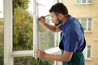 Construction worker installing new window in house