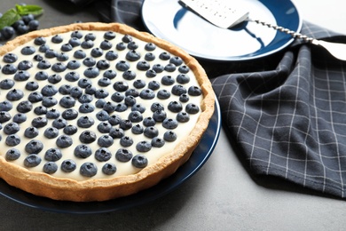 Tasty cake with blueberry on gray table