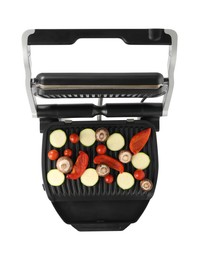 Photo of Electric grill with tomatoes, zucchini, bell pepper and mushrooms isolated on white, top view