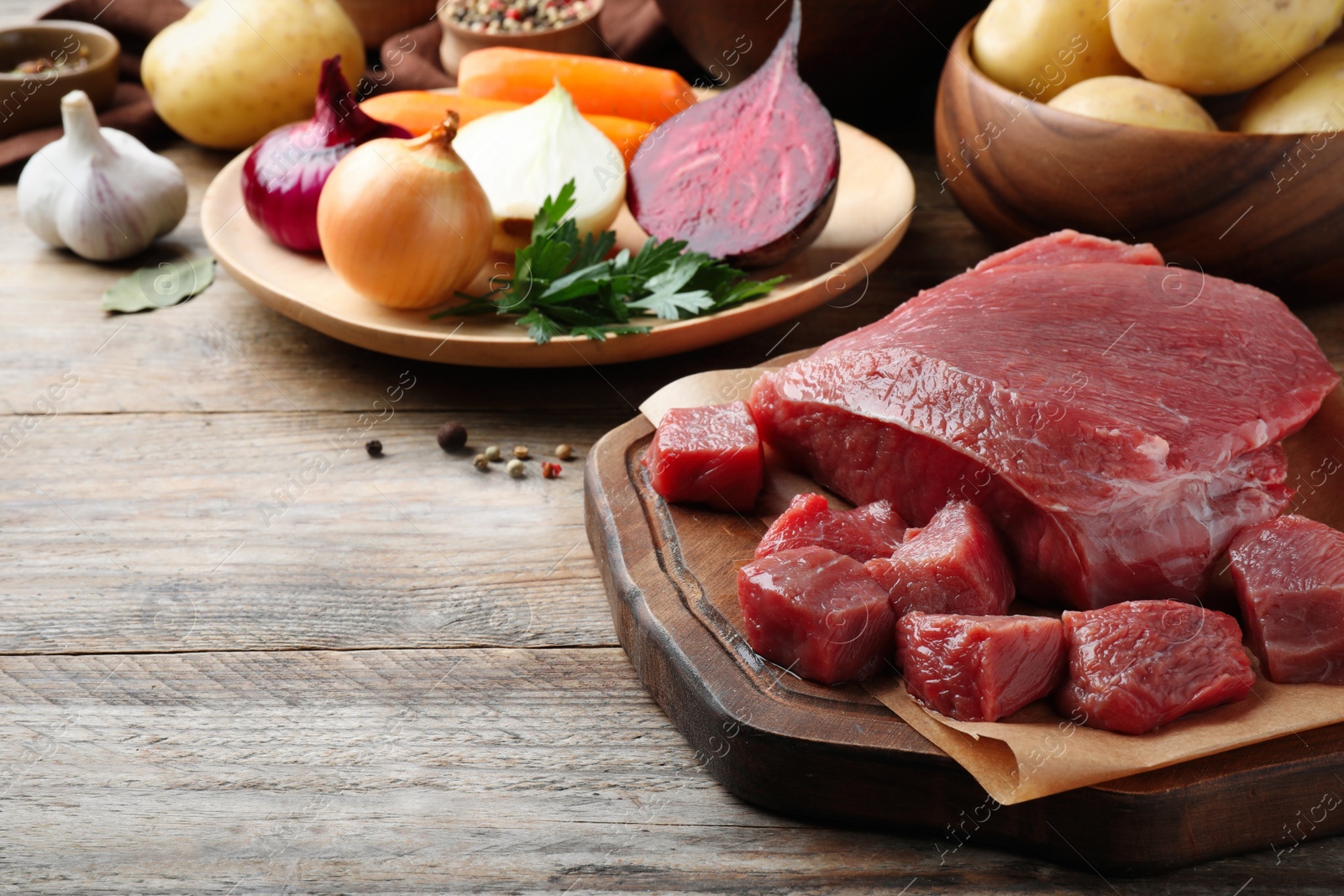 Photo of Fresh ingredients for borscht on wooden table, closeup