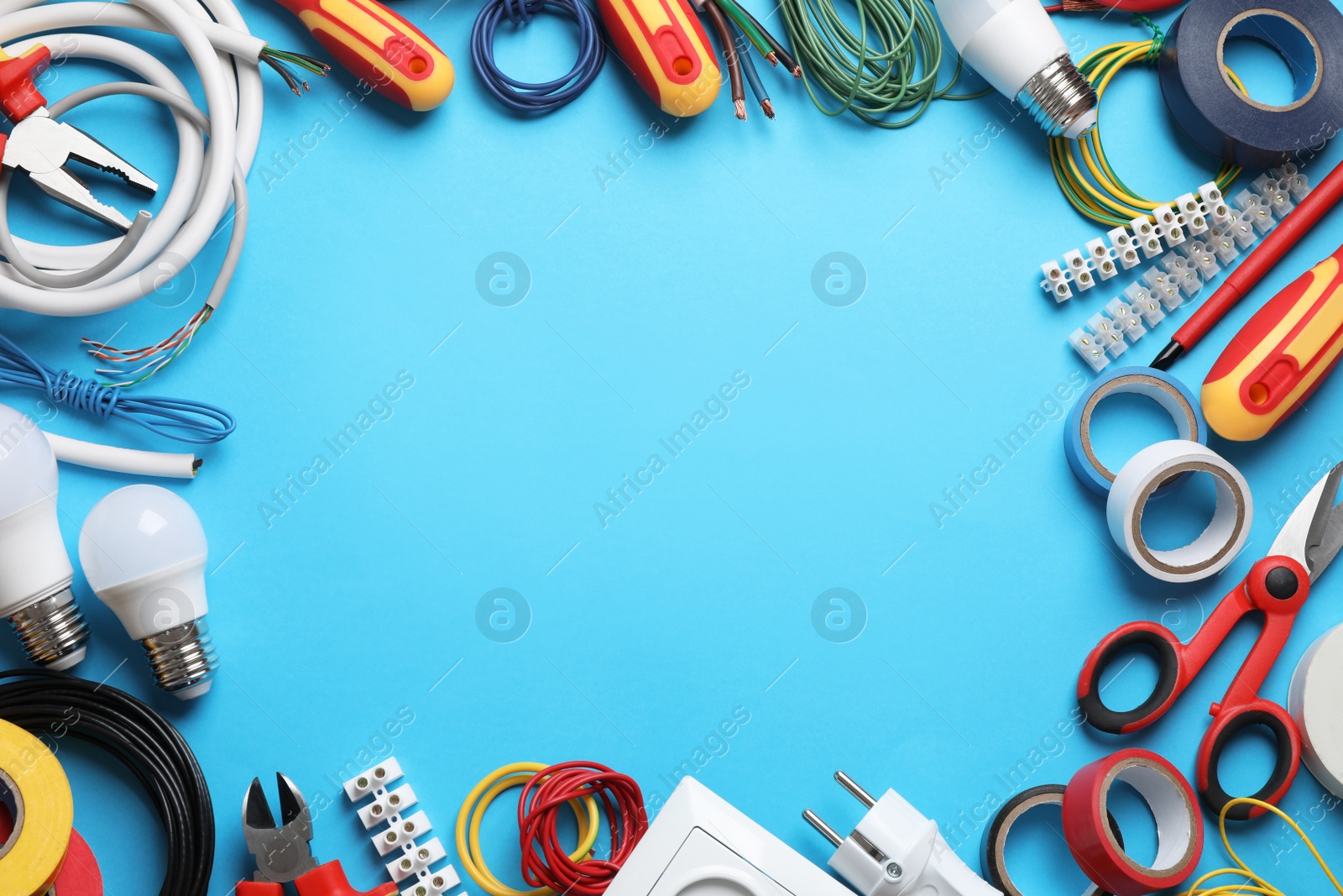 Photo of Frame of electrician's tools and accessories on light blue background, flat lay. Space for text