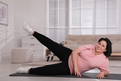 Overweight mature woman doing exercise at home