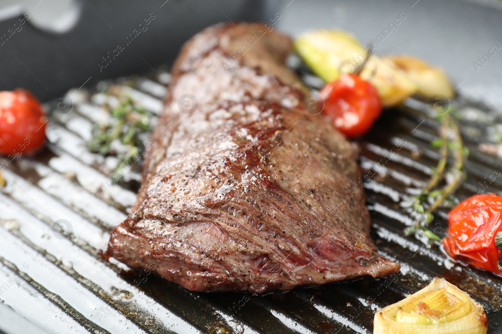 Photo of Delicious grilled beef meat and vegetables in pan, closeup