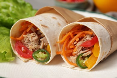 Photo of Delicious tortilla wraps with tuna on white plate, closeup