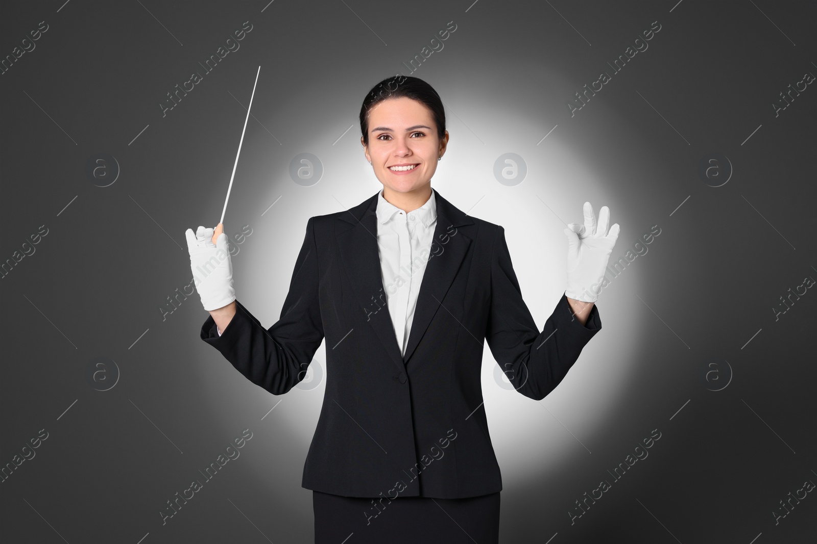 Photo of Happy professional conductor with baton on grey background