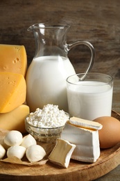 Different delicious dairy products on wooden tray