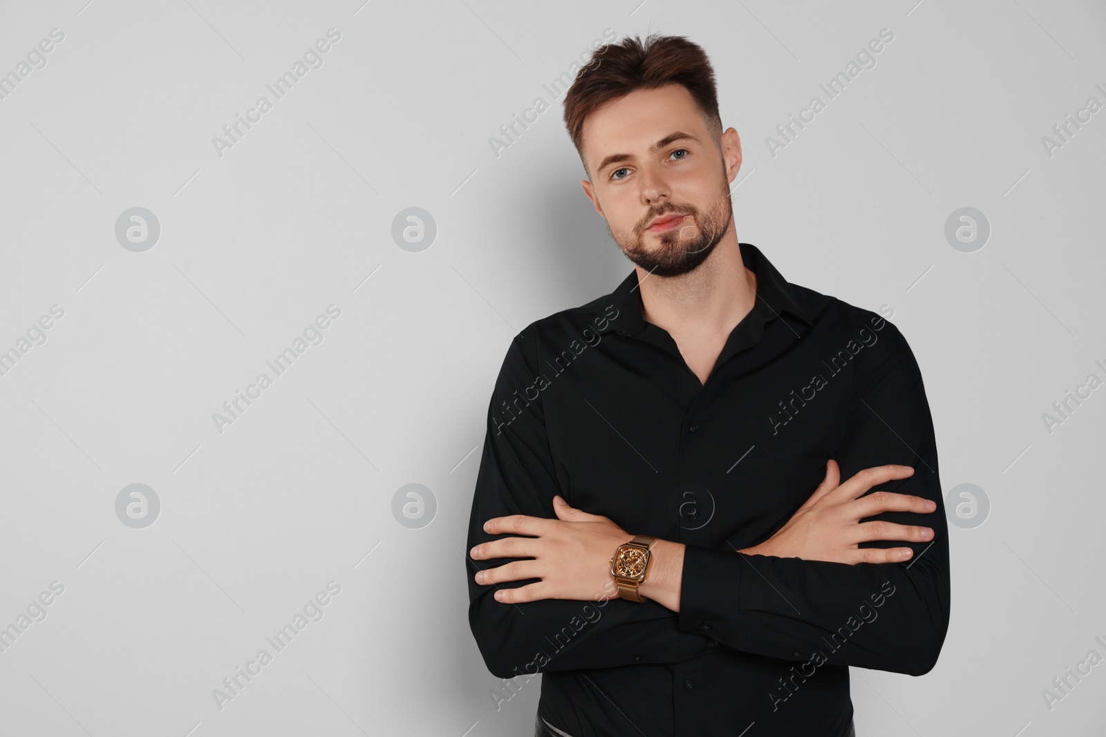 Photo of Handsome man in black shirt on light grey background, space for text