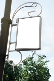 Photo of Blank poster on city street, low angle view. Space for design