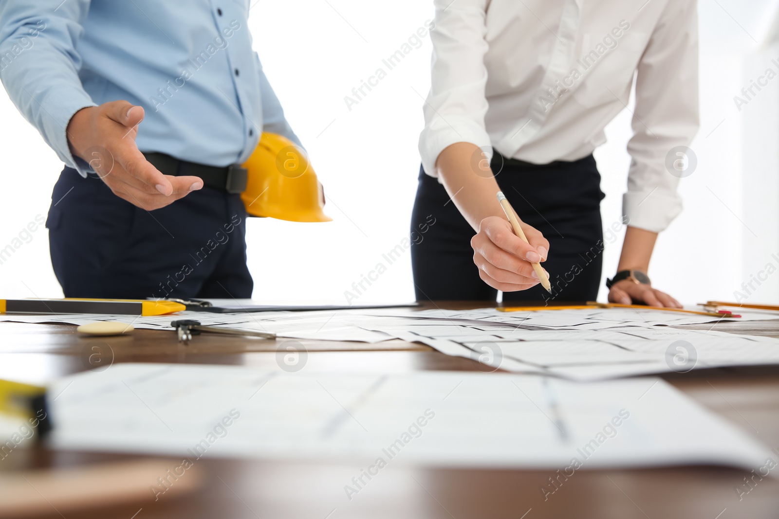 Photo of People working with construction drawings at table, closeup