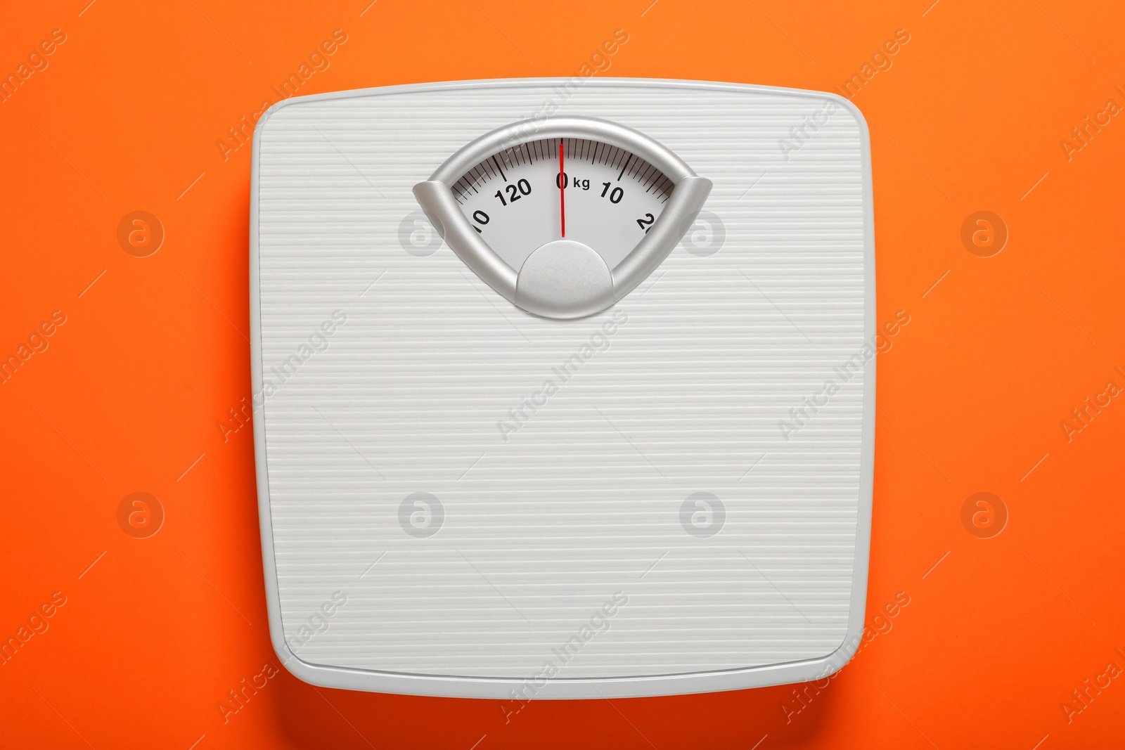 Photo of Bathroom scale on orange background, top view