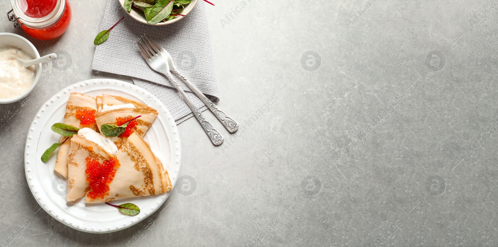 Image of Thin pancakes served with red caviar on table, top view. Banner design, space for text