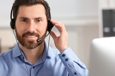 Photo of Hotline operator with headset working in office, space for text